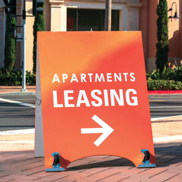 A photo of an orange sign with the words, "Apartments Leasing" in which text with a white arrow pointing right. Printed on GF 203HTAP.