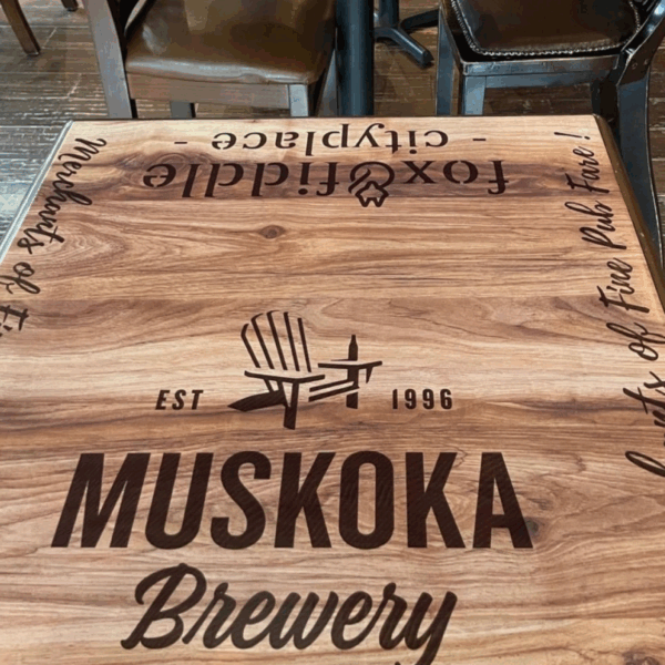 A photo of a wooden table with black text that says, "Muskoka Brewery." The text was printed on GF 205 and applied to the table.