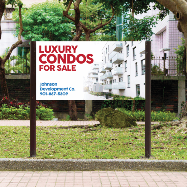 Photo of a residential street in a city with grass, trees, a brick sidewalk, and residential buildings in the background. In there foreground is a white sign attached to two black poles. On the sign there is a photo of one of the residential buildings that fades into white. In the top left corner there is large, red all-caps text that reads, "Luxury Condos for Sale." In the lower left there is smaller, blue regular case text that reads, "Johnson Development Co. 901-867-5309." The sign was printed on GF 220.