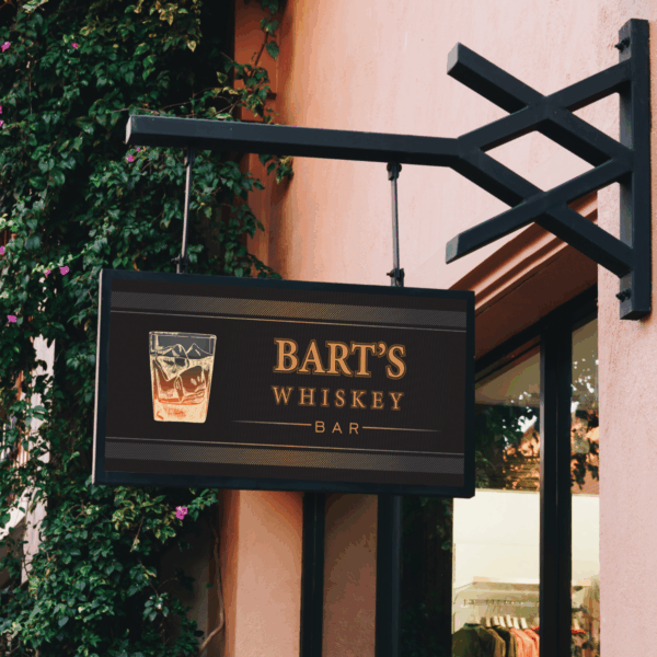 A photo of a black sign hanging off an iron sign holder on the side of a building. In marigold text is reads, "Bart's Whiskey Bar," next to an image of a glass of whiskey. The sign is printed on GF 203OP.