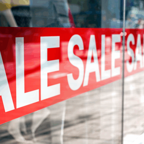 A photo of a red sign in a store window that reads, "SALE," in all caps white text. Printed on GF 207.