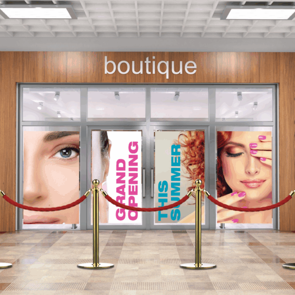 A photo of a storefront with the world, "Boutique," written above the doors in silver, all lower-case font. There are decals on the window containing photos of the faces of two women and the words, "Grand Opening," in all-caps pink text and "This Summer," in all-caps teal text. There is a red barrier rope on red stands in front of the door. The window decals were printed on GF 218.