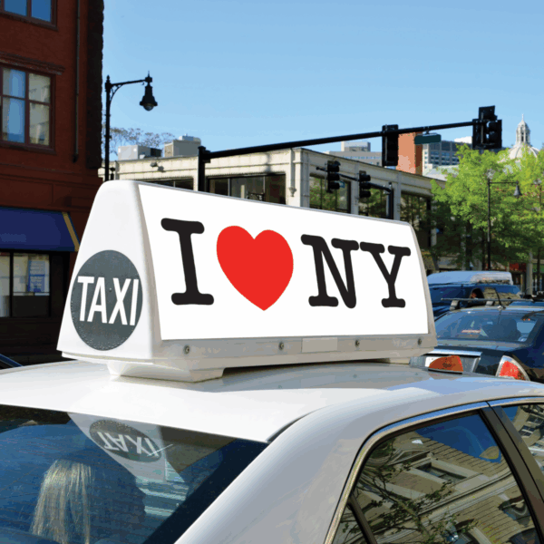 A photo of a topper on a white taxi cab. The topper contains the iconic, "I Heart NY" logo. The graphic on the topper was printed on GF 228.