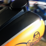 Photo of a yellow motorcycle with a textured, black decorative stripe. Both colors are separated by a silver stripe. There is a Harley Davidson logo barely visible on the bottom. The black was printed on GF 780.