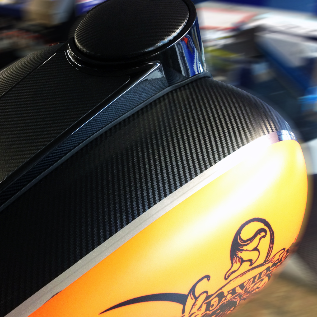 780_Dragon-Wrap_Image_square Photo of a yellow motorcycle with a textured, black decorative stripe. Both colors are separated by a silver stripe. There is a Harley Davidson logo barely visible on the bottom. The black was printed on GF 780.