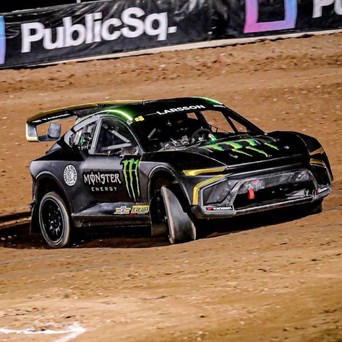 844_AutoMark-Cast_Image_square Photo of a race car racing on a dirt track. It is black with a spoiler on the back. There is a green Monster Energy Drink logo on the hood and sides. The wrap was printed on GF 844.