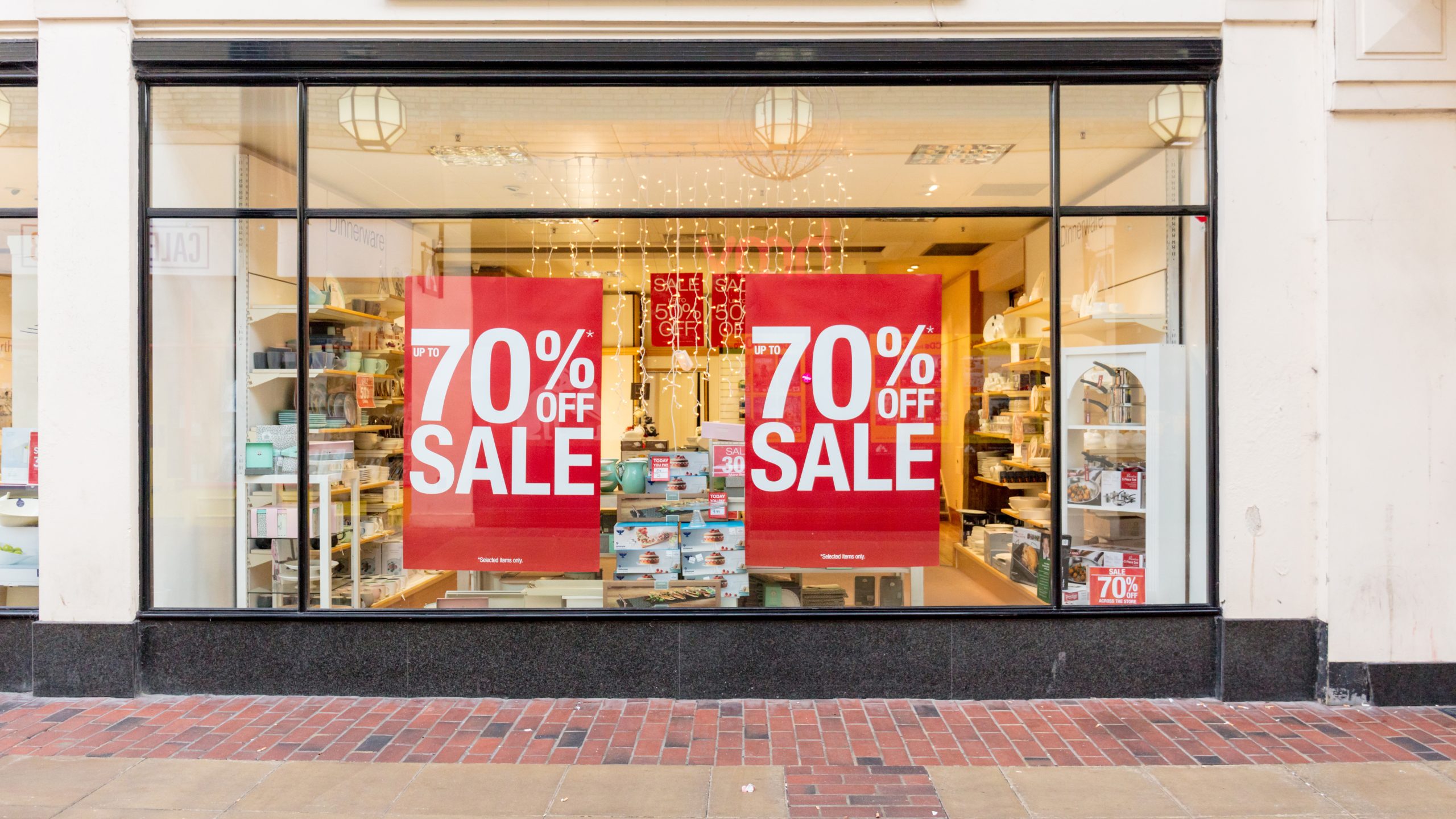 GF-365OP-scaled A photo of the window of a storefront. There are large red decals in the window that say, "70% off sale," in white. The decals are printed on GF 365OP.