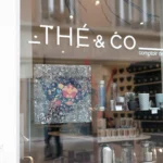 A photo of a clear window with whiter letters that read "Thé & Co." The Letters were printed on Kernow KlearView 142.