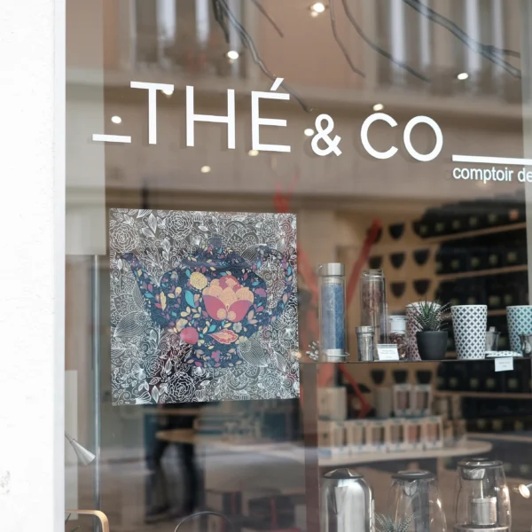 A photo of a clear window with whiter letters that read "Thé & Co." The Letters were printed on Kernow KlearView 142.